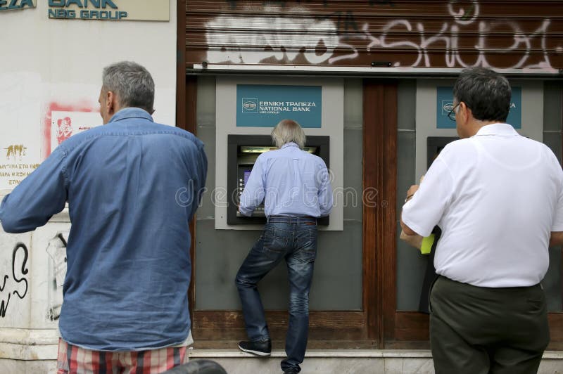 SALONICCO, GRECIA, IL 27 GIUGNO 2015: La gente sta in una coda per usare il ATMs di una banca I colloqui carichi del prestito della Grecia con i suoi creditori hanno preso un giro drammatico, con il governo che annuncia un referendum