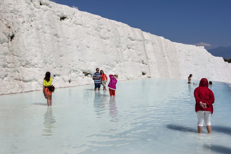 La gente sta in uno degli stagni termici ai travertini, o nel castello del cotone, a Pamukkale in Turchia fotografia stock