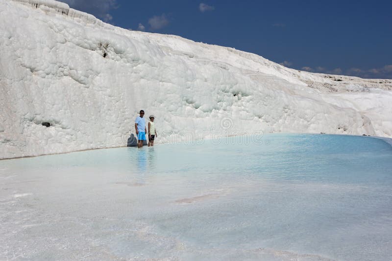 La gente sta in uno degli stagni termici ai travertini, o nel castello del cotone, a Pamukkale in Turchia fotografia stock