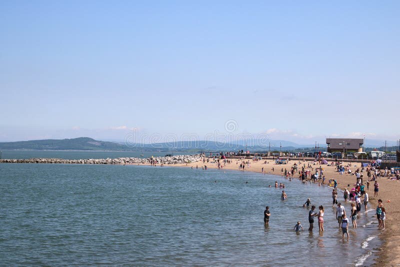La gente sulla spiaggia, giorno soleggiato, Morecambe, Lancashire fotografie stock libere da diritti La gente sulla spiaggia, giorno soleggiato, Morecambe, Lancashire fotografie stock libere da diritti