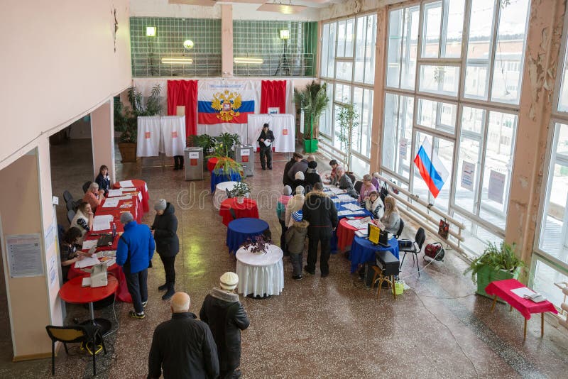 La gente è venuto a votare nel corridoio per il voto è decorata con i colori della bandiera russa fotografia stock La gente è venuto a votare nel corridoio per il voto è decorata con i colori della bandiera russa fotografia stock