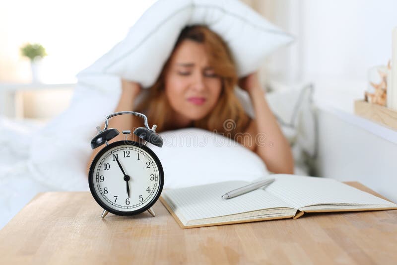 La giovane bella donna odia svegliare nelle prime ore del mattino immagini stock La giovane bella donna odia svegliare nelle prime ore del mattino immagini stock