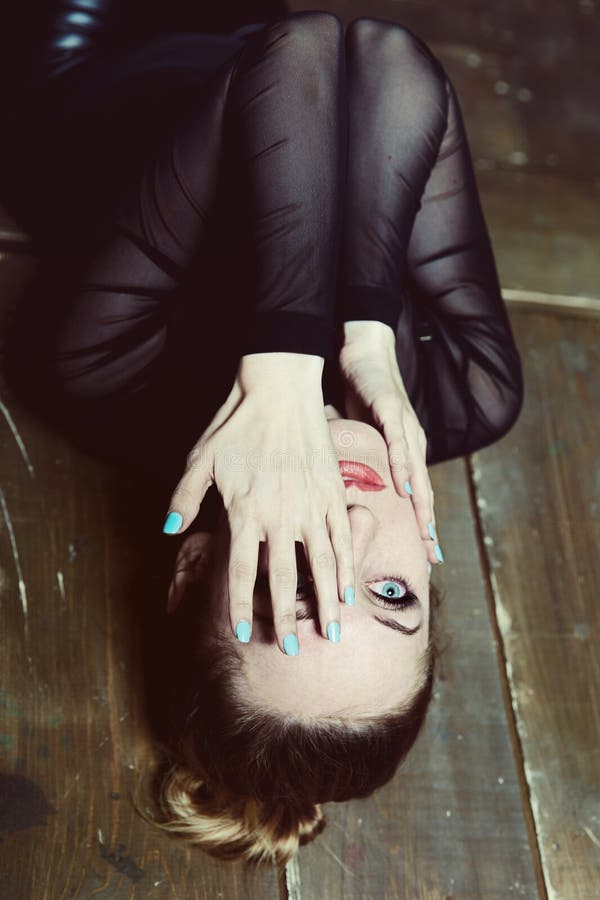La giovane bella donna si trova sul pavimento fotografie stock libere da diritti La giovane bella donna si trova sul pavimento fotografie stock libere da diritti