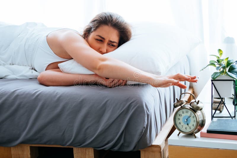 La giovane bella e donna caucasica attraente ha svegliato la menzogne sul letto nella mattina con la stanchezza e nella pigrizia fotografia stock La giovane bella e donna caucasica attraente ha svegliato la menzogne sul letto nella mattina con la stanchezza e nella pigrizia fotografia stock