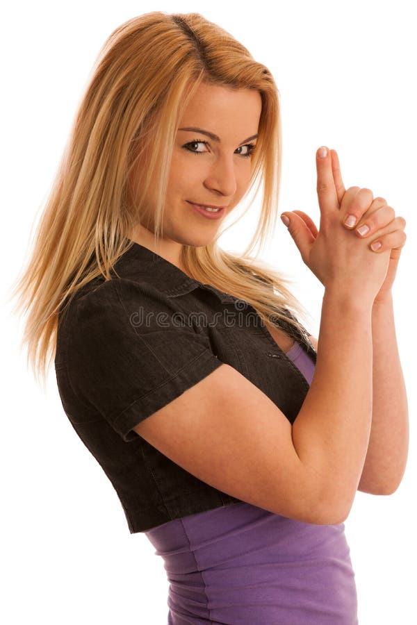 La giovane donna adolescente si tiene per mano in una forma della pistola come segno della p fotografia stock La giovane donna adolescente si tiene per mano in una forma della pistola come segno della p fotografia stock