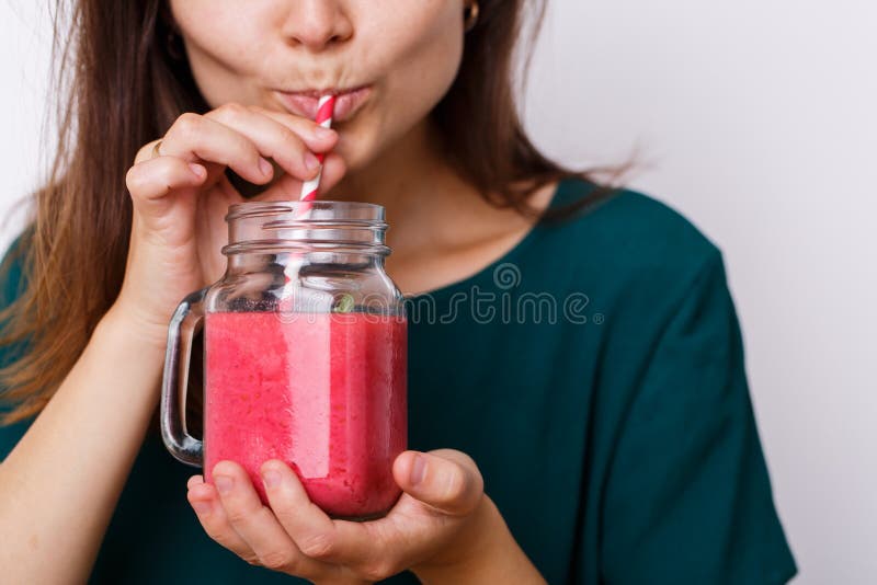 La giovane donna beve la bevanda della disintossicazione, frullato in barattolo di vetro fotografia stock libera da diritti La giovane donna beve la bevanda della disintossicazione, frullato in barattolo di vetro fotografia stock libera da diritti