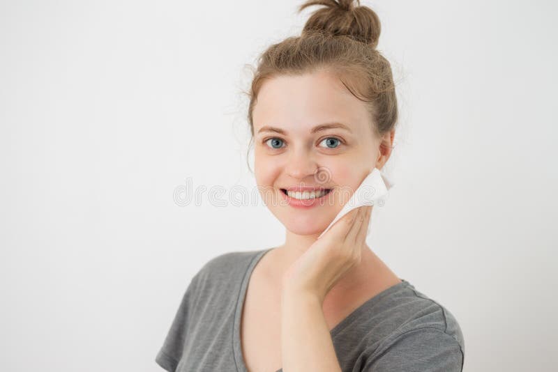 La giovane donna caucasica pulire il fronte con una strofinata, rimuovente compone fotografia stock La giovane donna caucasica pulire il fronte con una strofinata, rimuovente compone fotografia stock