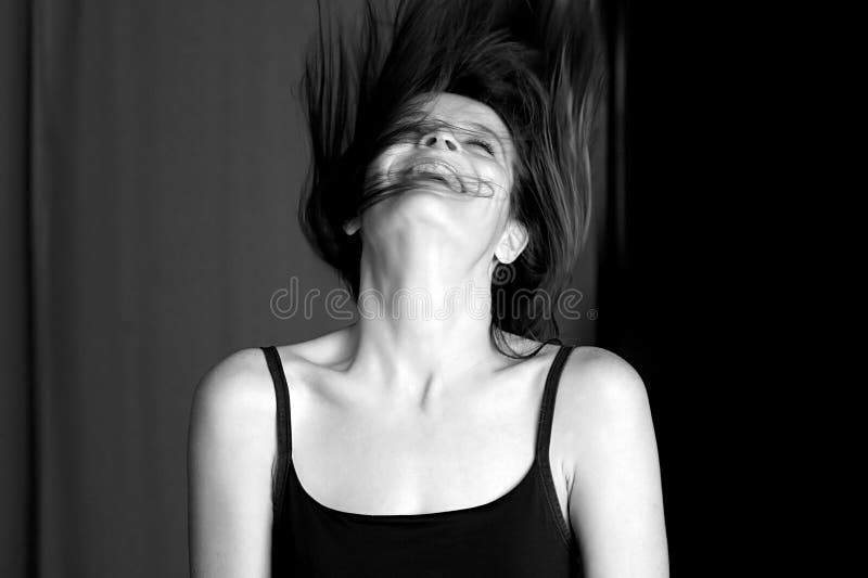 La giovane donna che ride e che getta sua si dirige indietro. fotografia stock libera da diritti
