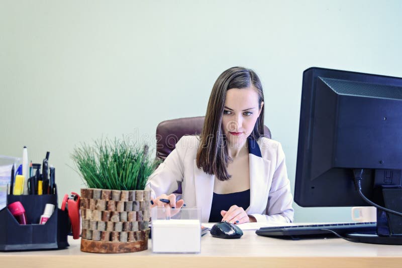 La giovane donna di affari che lavora duro sopra lo scrittorio nello studio, rendicontazione finanziaria del ragioniere dell'econ immagini stock libere da diritti La giovane donna di affari che lavora duro sopra lo scrittorio nello studio, rendicontazione finanziaria del ragioniere dell'econ immagini stock libere da diritti