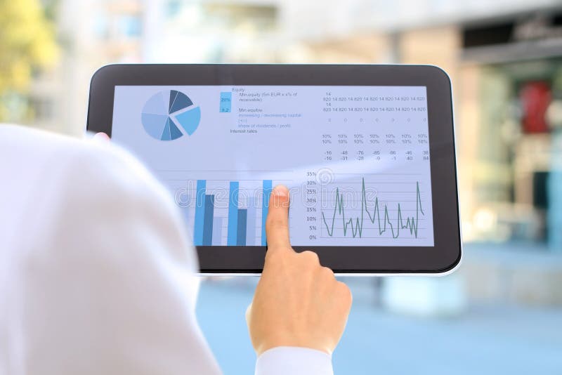 La giovane donna di affari che mostra i grafici dal dito al digitale immagine stock La giovane donna di affari che mostra i grafici dal dito al digitale immagine stock