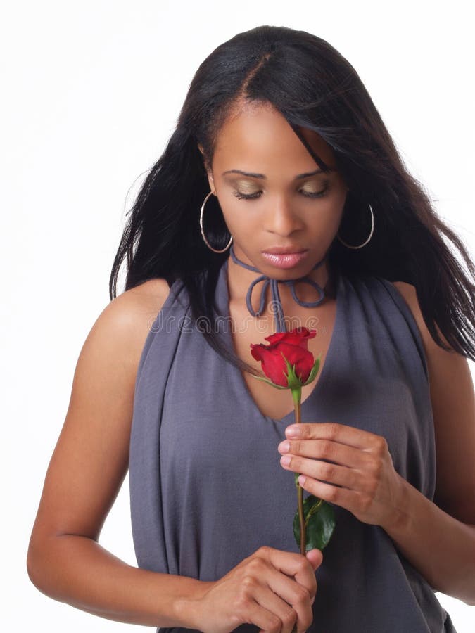 La giovane donna di colore che osserva giù il colore rosso è aumentato fotografia stock libera da diritti La giovane donna di colore che osserva giù il colore rosso è aumentato fotografia stock libera da diritti