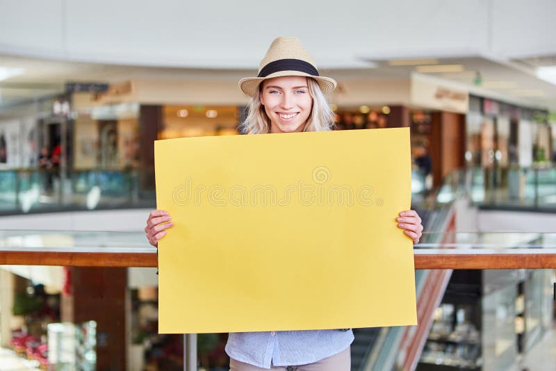La giovane donna di vendita sta tenendo l'insegna in bianco gialla fotografia stock libera da diritti La giovane donna di vendita sta tenendo l'insegna in bianco gialla fotografia stock libera da diritti