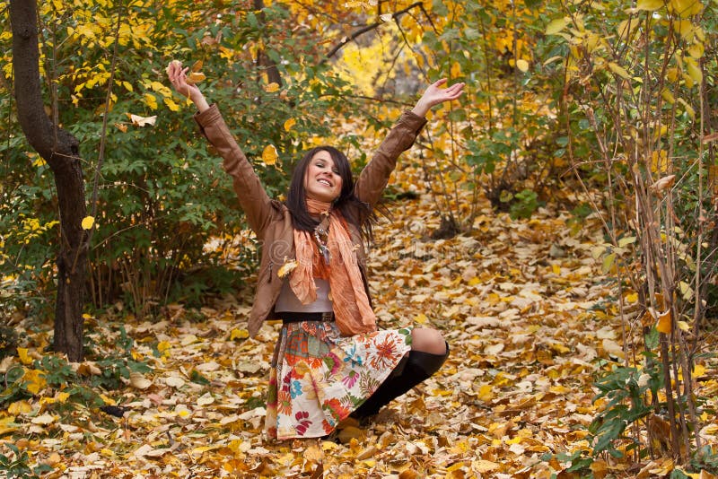La giovane donna felice gode dell'autunno fotografie stock libere da diritti La giovane donna felice gode dell'autunno fotografie stock libere da diritti