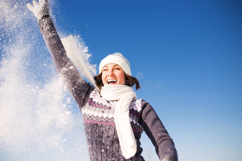 La giovane donna felice si diverte e gode della neve fresca fotografia stock libera da diritti La giovane donna felice si diverte e gode della neve fresca fotografia stock libera da diritti