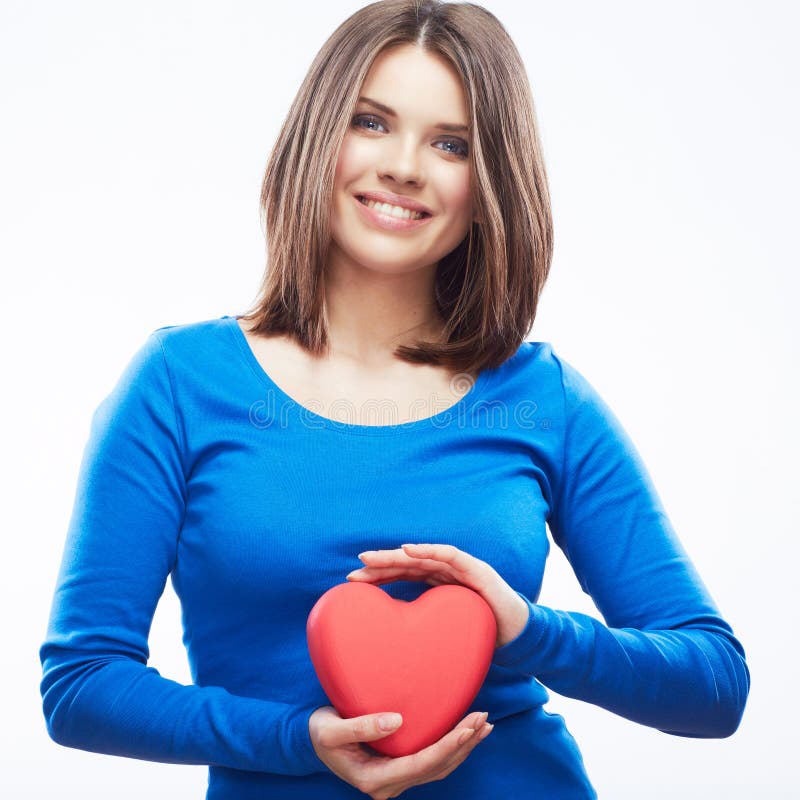 La giovane donna sorridente tiene il cuore rosso, simbolo di giorno di S. Valentino Ragazza fotografia stock libera da diritti La giovane donna sorridente tiene il cuore rosso, simbolo di giorno di S. Valentino Ragazza fotografia stock libera da diritti