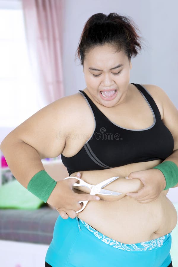 Giovane donna taglia il grasso addominale fotografia stock libera da diritti