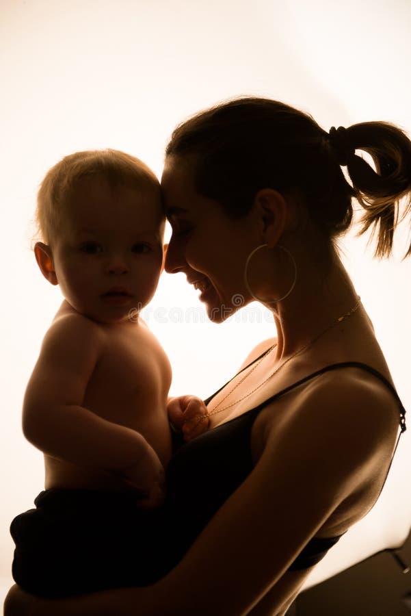 La giovane madre felice bacia il figlio bambino. fotografia stock