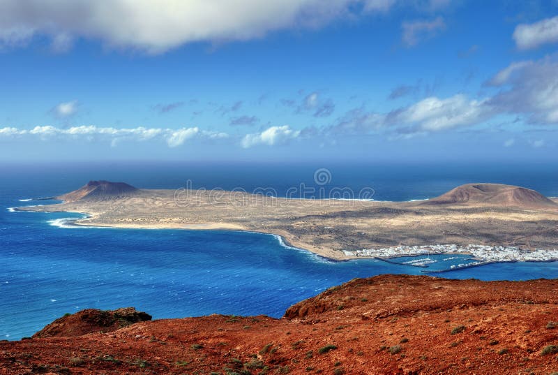 The Island of La Graciosa and the port of Caleta del Sebo taken from the Mirador del Rio, a famous viewpoint on Lanzarote, in the Spanish Canary Islands. The Island of La Graciosa and the port of Caleta del Sebo taken from the Mirador del Rio, a famous viewpoint on Lanzarote, in the Spanish Canary Islands.