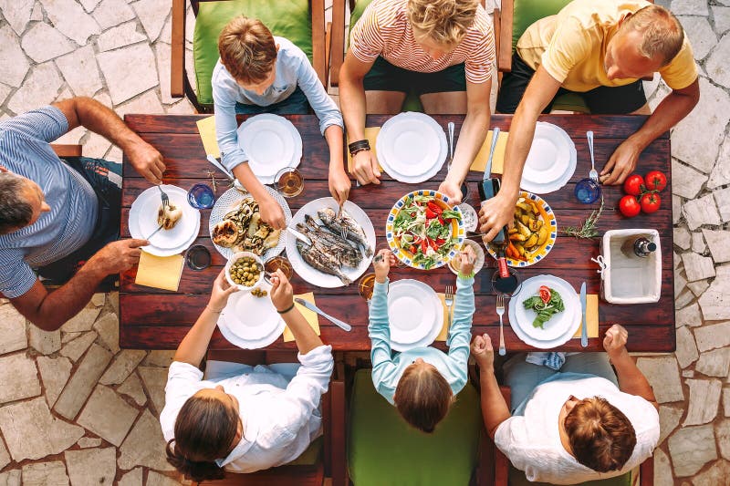 La grande famiglia ha una cena con il piatto cucinato fresco sul giardino aperto t fotografia stock
