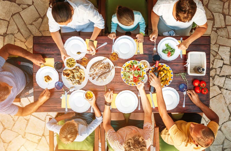 La grande famiglia ha una cena con il piatto cucinato fresco sul giardino aperto t immagine stock libera da diritti