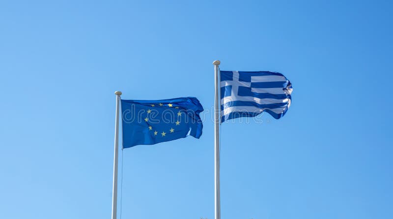 La Grecia e UE Bandiere di Unione Europea e greche che ondeggiano sul chiaro cielo blu immagini stock libere da diritti La Grecia e UE Bandiere di Unione Europea e greche che ondeggiano sul chiaro cielo blu immagini stock libere da diritti