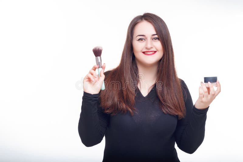 La grosse brune gaie a l'amusement posant avec du cosmétique Modèle plus de taille, combinaison d'usage dans le studio avec de gr photo libre de droits La grosse brune gaie a l'amusement posant avec du cosmétique Modèle plus de taille, combinaison d'usage dans le studio avec de gr photo libre de droits