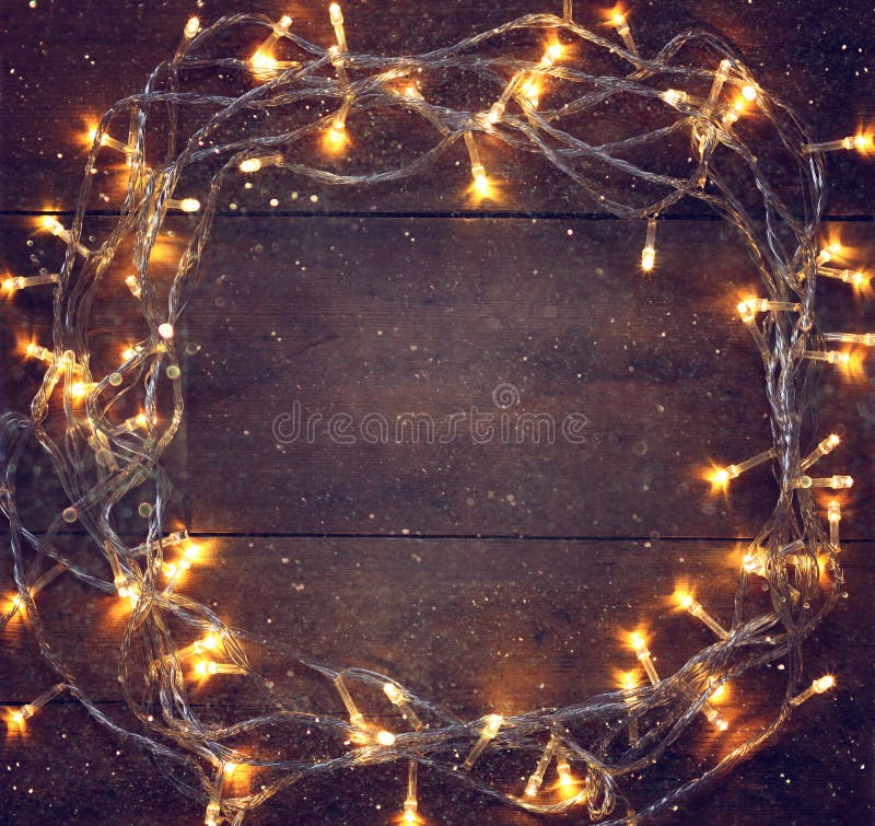 La guirnalda caliente del oro de la Navidad colorida se enciende en fondo rústico de madera Imagen filtrada fotos de archivo libres de regalías La guirnalda caliente del oro de la Navidad colorida se enciende en fondo rústico de madera Imagen filtrada fotos de archivo libres de regalías