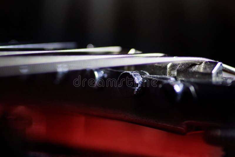 La guitare électrique rouge dans le macro, ficelles se ferment, détail d'instrument de musicien photographie stock La guitare électrique rouge dans le macro, ficelles se ferment, détail d'instrument de musicien photographie stock