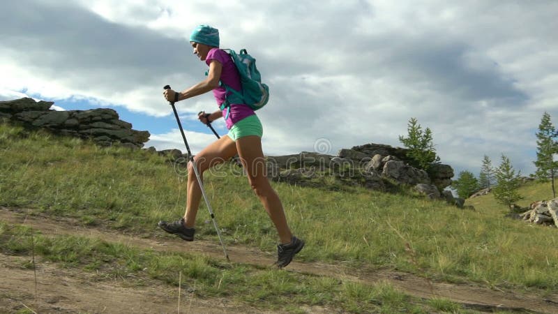 La hembra activa joven corre al aire libre en el verano soleado