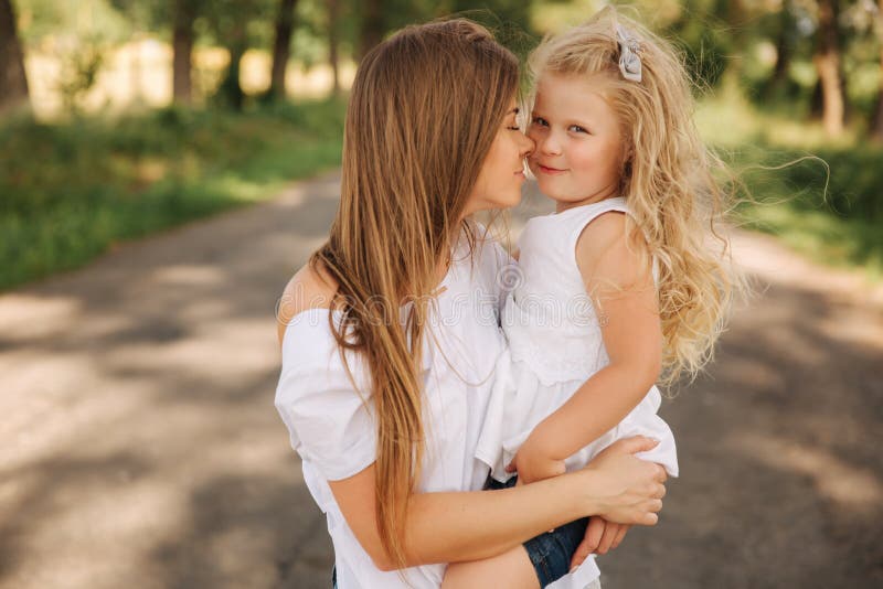 Attractive Mom and Blonde Hair Daughter Sits on Road Near Bi