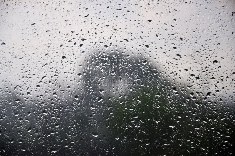 La imagen de fondo de la lluvia cae en una ventana de cristal Foto macra con la profundidad del campo baja imagen de archivo libre de regalías La imagen de fondo de la lluvia cae en una ventana de cristal Foto macra con la profundidad del campo baja imagen de archivo libre de regalías