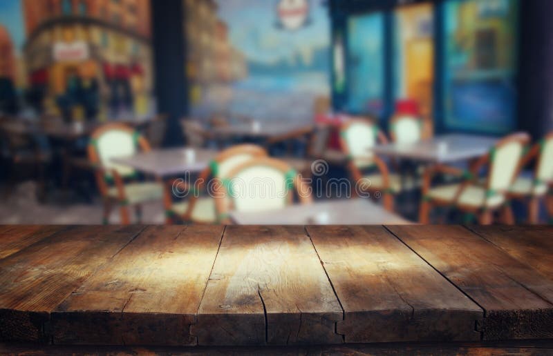 La imagen de la tabla de madera delante del extracto empañó el fondo de las luces del restaurante foto de archivo La imagen de la tabla de madera delante del extracto empañó el fondo de las luces del restaurante foto de archivo