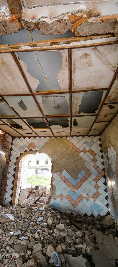La imagen representa un interior de edificio dañado con vigas de yeso caídas y suelo desigual. No hay muebles ni imagen de archivo libre de regalías