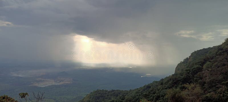 La imagen representa un sol brillando a través de las nubes creando una hermosa interacción de luz y sombra en el cielo. foto de archivo