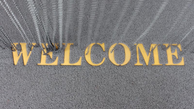 La inscripción bienvenida en una alfombra bajo las cadenas colgadas