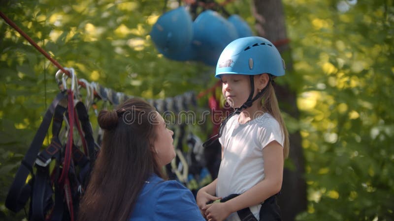 La investigadora pone un casco protector a la muchacha antes de la atracción extrema en el bosque