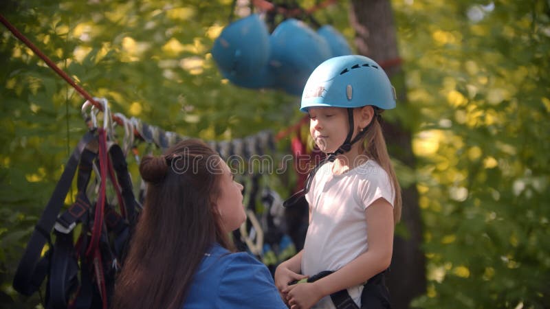 La investigadora pone un casco protector a la niña antes de la atracción en el bosque