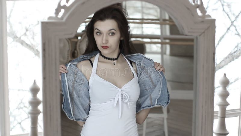 La jeune belle femme regarde sa réflexion dans le miroir banque de vidéos