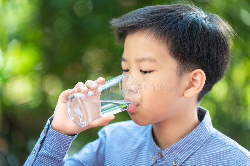 La jeune eau asiatique de boissons de garçon