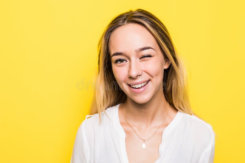 La jeune femme blonde a habillé faire en passant des visages à la caméra, clignotement d'isolement sur le fond jaune photos libres de droits La jeune femme blonde a habillé faire en passant des visages à la caméra, clignotement d'isolement sur le fond jaune photos libres de droits