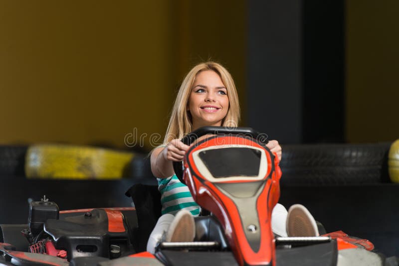 La jeune femme conduit la voiture de kart image libre de droits La jeune femme conduit la voiture de kart image libre de droits