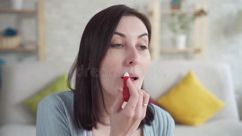 La jeune femme de portrait peut a gercé se reposer de rouge à lèvres de traitement de lèvre banque de vidéos