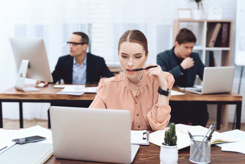 La jeune femme détend au travail Elle regarde les achats images stock La jeune femme détend au travail Elle regarde les achats images stock
