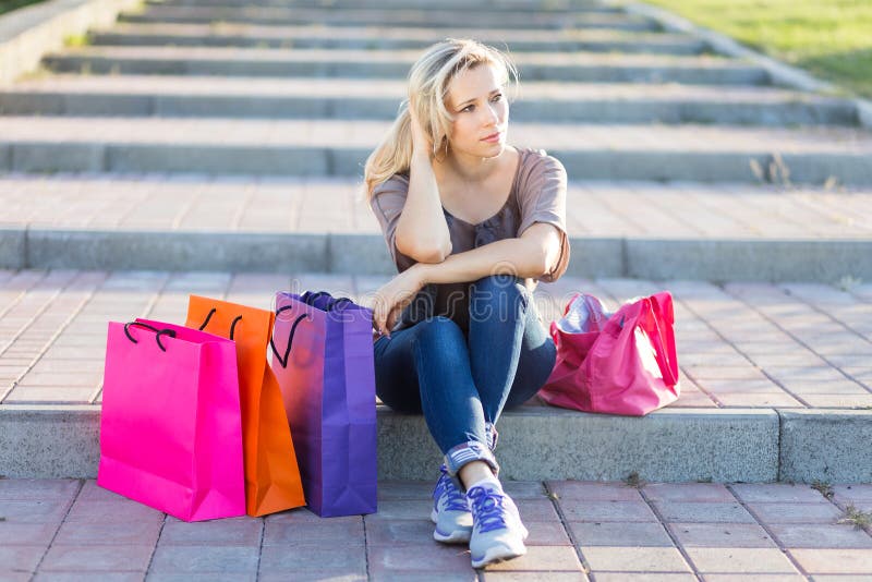 La jeune femme détendent sur des escaliers après l'achat images libres de droits La jeune femme détendent sur des escaliers après l'achat images libres de droits