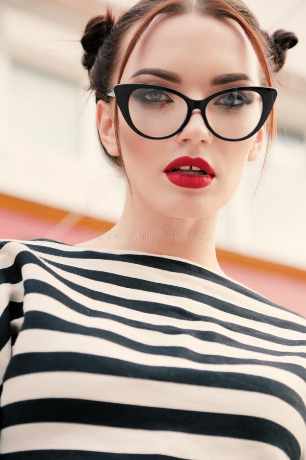 La jeune femme magnifique avec les cheveux foncés dans des vêtements sport porte des glas image libre de droits La jeune femme magnifique avec les cheveux foncés dans des vêtements sport porte des glas image libre de droits