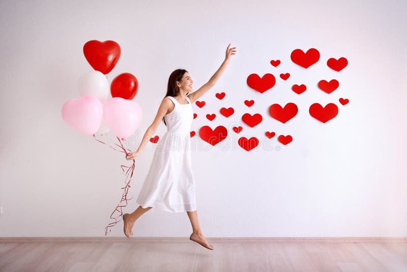 La jeune femme romantique avec des ballons s'approchent du mur photographie stock libre de droits La jeune femme romantique avec des ballons s'approchent du mur photographie stock libre de droits