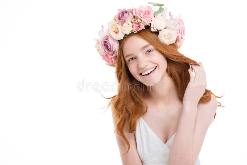 La jeune femme rousse heureuse gaie dans les roses tressent