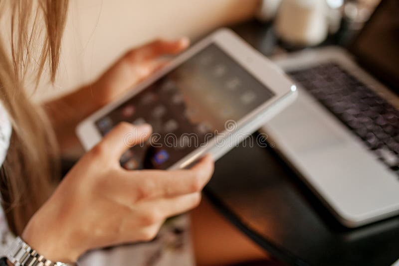 La jeune femme utilise le comprimé en café photographie stock La jeune femme utilise le comprimé en café photographie stock