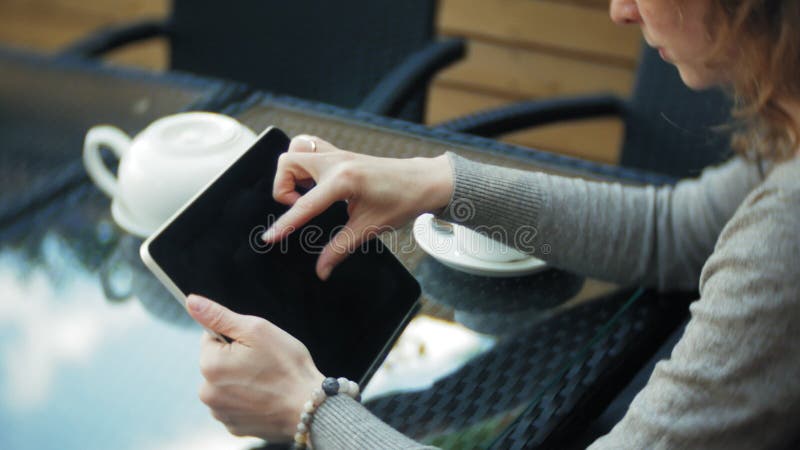 La jeune femme utilise un comprimé et le téléphone, boit du thé dans une barre de café clips vidéos