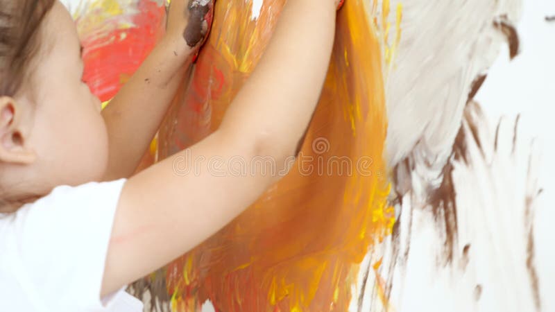 La jeune fille créative comptant les peintures jaunes et rouges sur la toile.